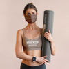 Woman With Face Mask Holding Yoga Mat Psd