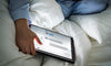 A Woman Using A Tablet In Bed Psd