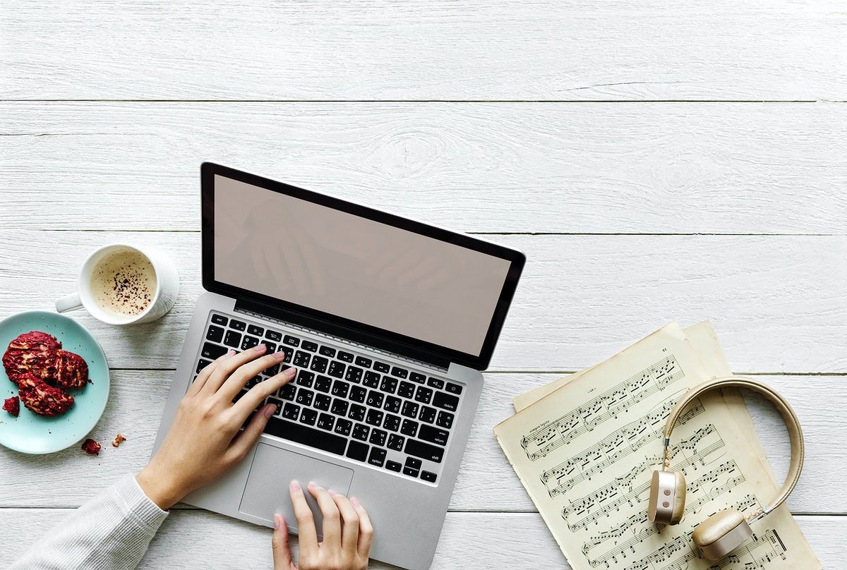 Aerial View Of Woman Using A Computer Laptop On Wooden Table Music Workspace Concept