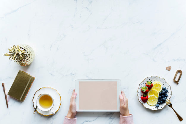 Aerial View Of Woman Using A Digital Tablet On A Marble Table With Design Space Psd