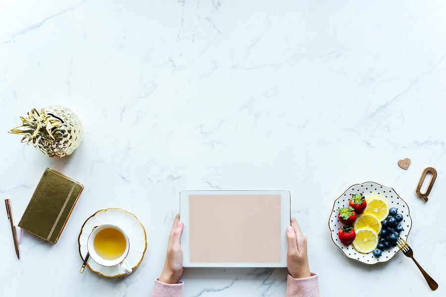 Aerial View Of Woman Using A Digital Tablet On A Marble Table With Design Space