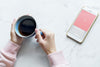 Aerial View Of Woman With A Hot Cup Of Coffee And A Smartphone Psd