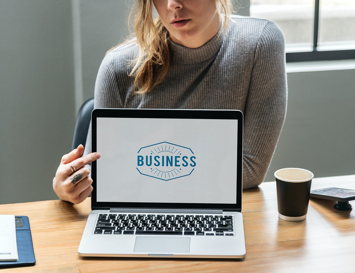 Blond Woman Pointing At A Laptop Screen