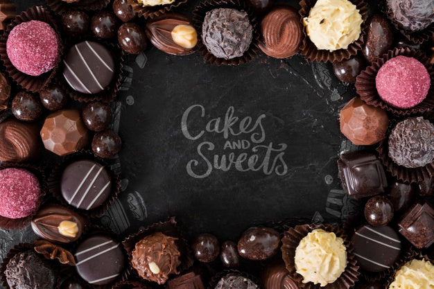 Cakes And Sweets Surrounded By Pralines And Candies Psd