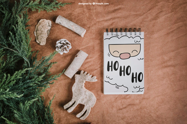 Christmas Mockup With Notepad Next To Fir Psd