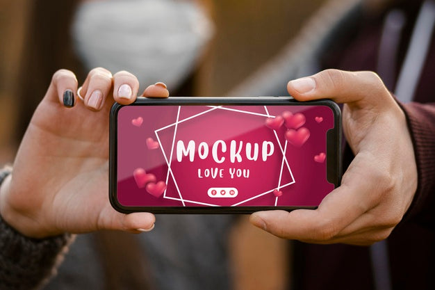 Close-Up Couple With Mask Holding Phone Psd