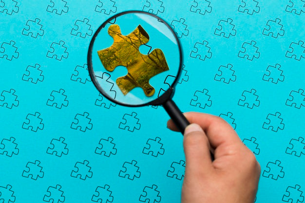 Close-Up Man Looking At A Piece Of Puzzle Psd