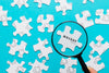 Close-Up Man With Magnifying Glass And Pieces Of Puzzle Psd