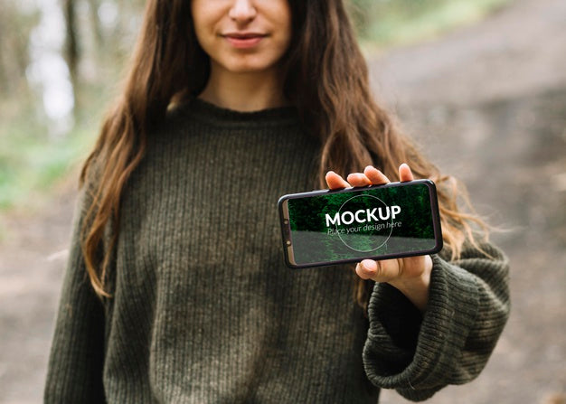 Cute Woman In Nature With Smartphone Mock-Up Psd