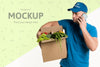 Delivery Man Holding A Box Full With Vegetables While Talking On The Phone Psd