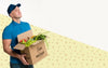Delivery Man Holding A Box With Different Vegetables Mock-Up Psd