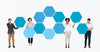 Diverse People Showing Blue Hexagon Shaped Boards