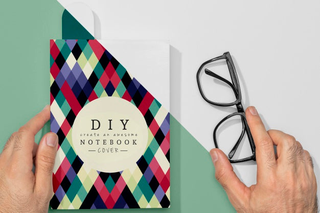 Flat Lay Hand Holding Book Mock-Up And Glasses Psd
