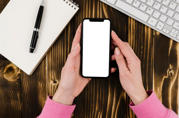 Flat Lay Hands Holding Smartphone Mock-Up With Notepad Psd