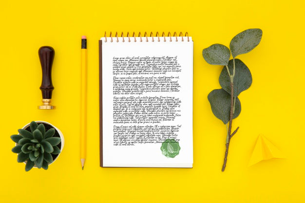 Flat Lay Of Desk Surface With Notebook And Leaves Psd