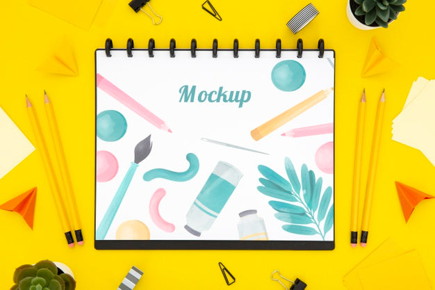 Flat Lay Of Desk Surface With Notebook And Pencils Psd