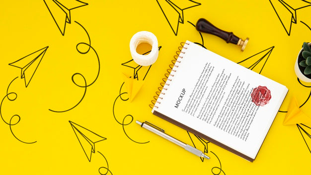 Flat Lay Of Desk Surface With Notepad And Seal Psd