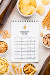 Flat Lay Of Notebook With Assortment Of Snacks And Beer Bottles Psd