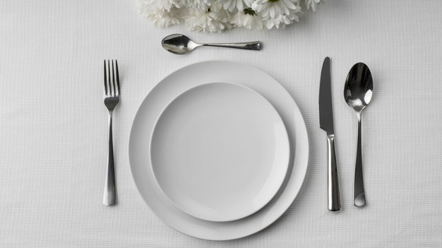 Flat Lay Of Plates On Table With Cutlery And Flowers Psd