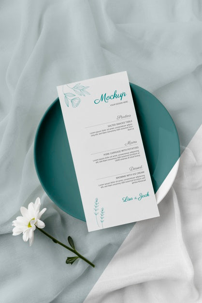 Flat Lay Of Table Arrangement With Spring Menu Mock-Up On Plate And Flower Psd