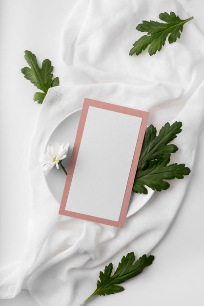 Flat Lay Of Table Arrangement With Spring Menu Mock-Up On Plate With Leaves And Flower Psd