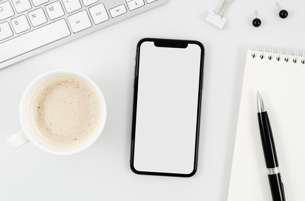 Flat Lay Smartphone Mock-Up With Empty Cup On Desk Psd