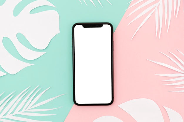 Flat Lay Smartphone Mock-Up With Leaves On Desk Psd