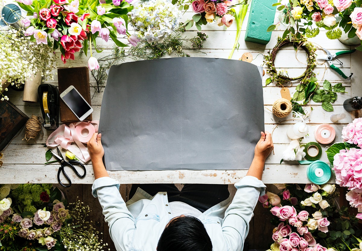 Florist Showing Empty Design Space Paper On Wooden Table With Fresh Flowers Decorate
