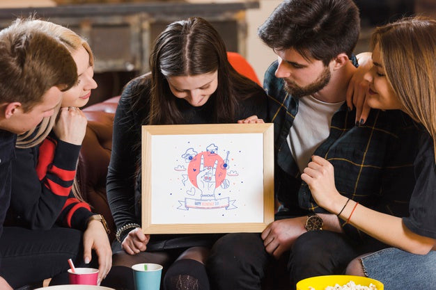 Friends Looking At A Frame Mock-Up While Holding It Psd