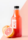 Front View Glass Juice Bottle With Grapefruits Psd