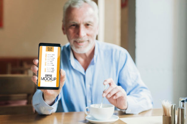 Front View Man In Coffee Shop Holding Mobile Mock-Up Psd