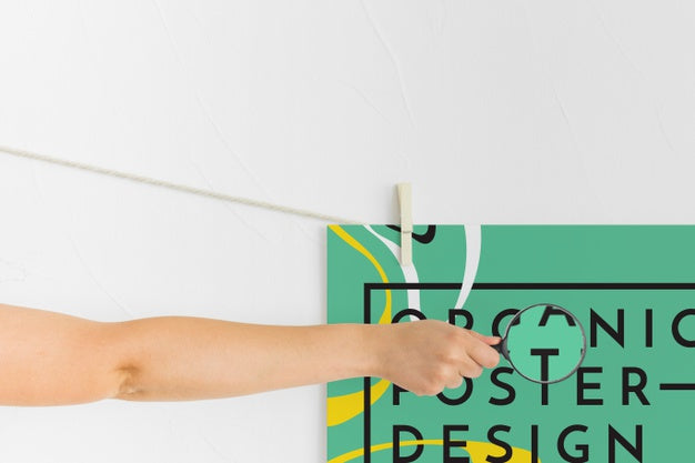 Front View Of Arm Holding Magnifying Glass Over Poster Psd