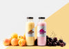 Front View Of Clear Juice Bottles With Cherries And Peaches Psd