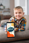 Front View Of Defocused Kid On Couch Holding Smartphone Psd
