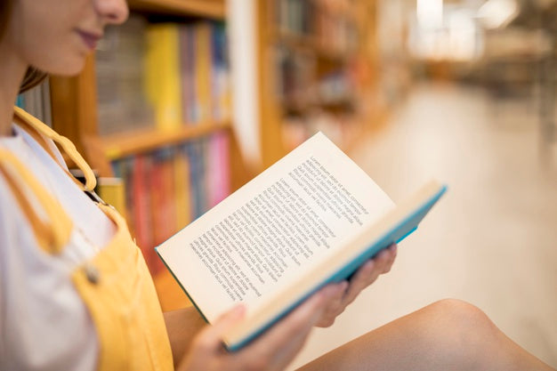 Front View Of Girl Reading In The Library Psd