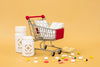 Front View Of Medicine Bottles With Pills And Shopping Cart Psd