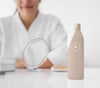 Front View Of Moisturizer Bottle On The Table With Defocused Woman Psd