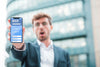 Front View Of Shocked Businessman Holding Smartphone Psd