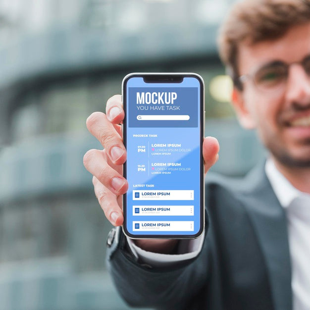 Front View Of Smiley Businessman Holding Smartphone Psd