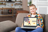 Front View Of Smiley Kid On Couch Holding Laptop Psd
