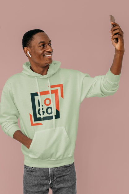 Front View Of Stylish Man In Hoodie With Earbuds Taking Selfie Psd