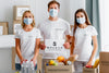 Front View Of Volunteers With Medical Masks Holding Blank Paper Next To Food Box Psd