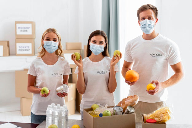 Front View Of Volunteers With Medical Masks Preparing Food Donations Psd
