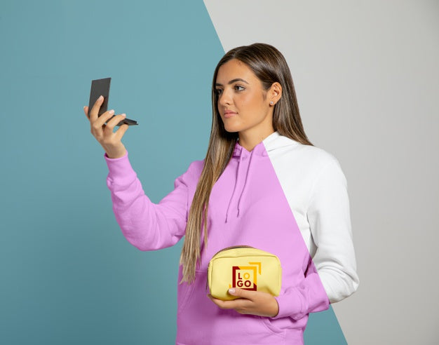 Front View Of Woman In Hoodie Holding Make-Up Pouch And Looking In The Mirror Psd