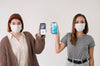 Front View Of Women With Masks Holding Smartphones Psd