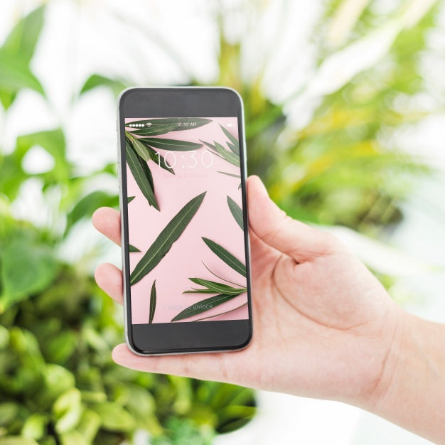 Gardening Concept With Hand Holding Smartphone Psd