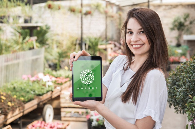 Girl Holding Tablet Mockup With Gardening Concept Psd