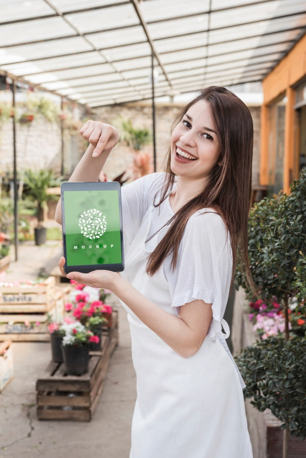 Girl Holding Tablet Mockup With Gardening Concept Psd
