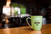 Green Coffee Cup On Wooden Table Psd