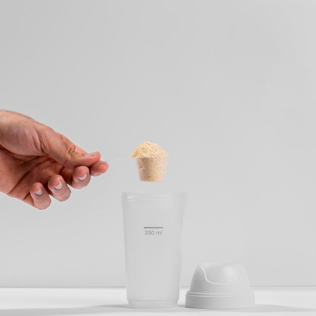 Hand Holding Fitness Spoon Filled With Protein Above Shaker Psd